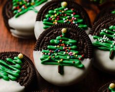 cookies decorated with green and white icing are arranged on a table