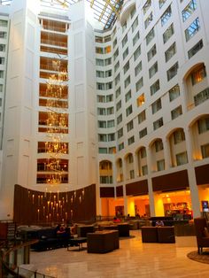 the inside of a large hotel lobby with chandeliers hanging from it's ceiling