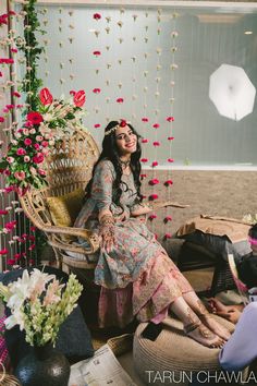 a woman sitting in a chair surrounded by flowers