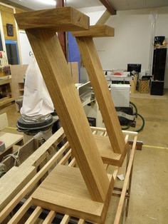 an unfinished piece of wood sitting on top of a wooden shelf in a room filled with tools