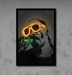 a neon sign with a man's face and sunglasses on it, against a concrete wall