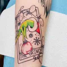 a tattoo on the arm of a person with an ornament and christmas decorations