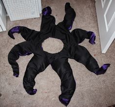 a person in a black and purple costume laying on the floor