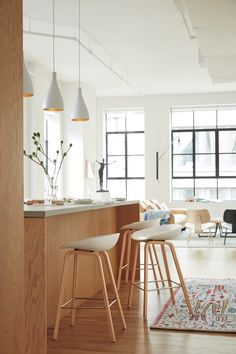 a living room filled with furniture next to a kitchen and dining room table in front of a window