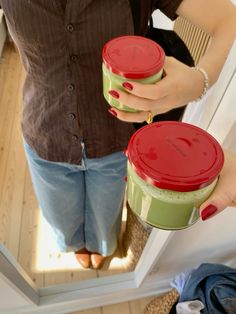 a woman holding two red and green containers