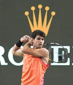 a man holding a tennis racquet on top of a tennis court with a crown above his head