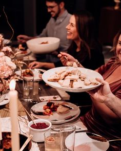 a group of people sitting at a table with plates of food in front of them