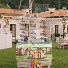 a wooden easel with a seating chart on it in front of a building and lawn