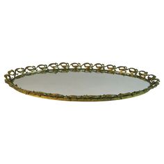 an oval metal tray with rings on the bottom and sides, sitting on a white surface