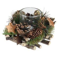 a candle holder filled with pine cones and branches