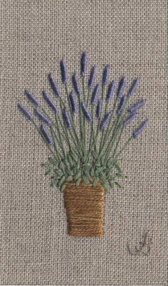 a small potted plant with blue flowers in it on a beige background, next to a pair of scissors