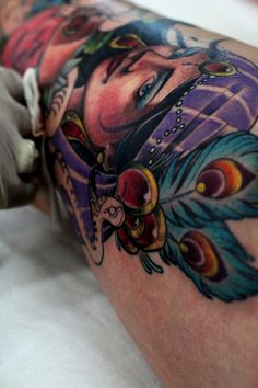 a man with tattoos on his leg and arm is getting inked by an artist