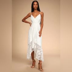 a woman is wearing a white dress with an asymmetrical design on it