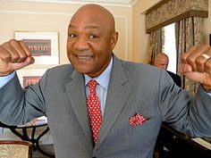 a man in a suit and tie posing for the camera with his hands up,