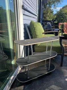 a skateboard sitting on top of a metal shelf next to a chair and table