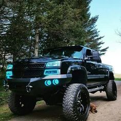 a large black truck parked on top of a dirt road