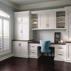 a home office with white cabinets and blue chair in the center, along with hardwood floors