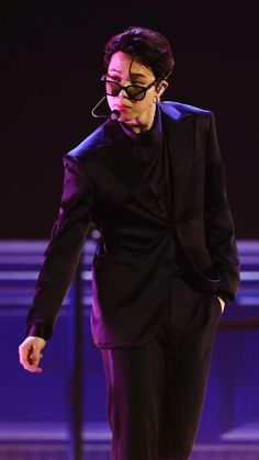 a man in a suit and tie walking on stage