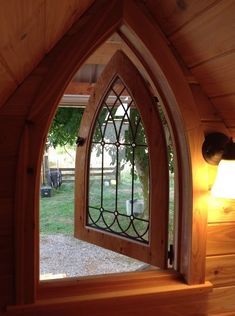 an arched window is shown in the corner of a room with wood walls and flooring