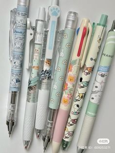 several pens lined up on top of each other in different colors and designs, with the same pen attached to them