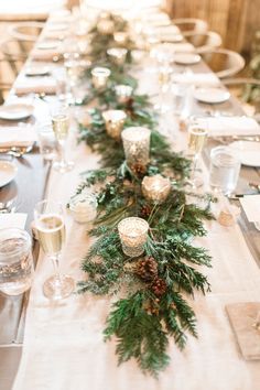 a long table is set with candles and greenery for a festive holiday dinner