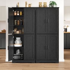 a kitchen with black cabinets and wooden floors