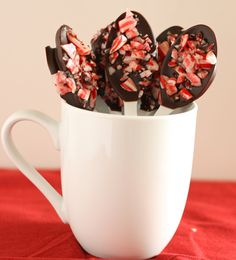 chocolate covered candies in a white cup on a red tablecloth