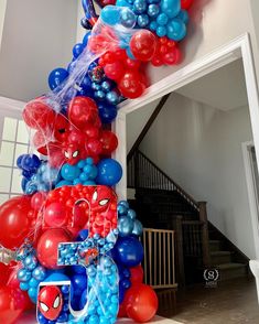 balloons are arranged in the shape of spiderman's head on display at a party