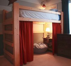 a bunk bed with red curtains is in the corner of a room next to a night stand