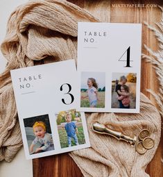 the table numbers are displayed on top of some yarn and a pair of gold scissors