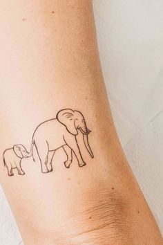 an elephant and her baby tattoo on the left arm, which is drawn in black ink