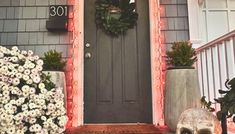 a front door decorated for halloween with wreaths and skulls