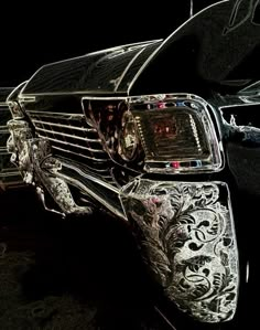 the front end of a black car with intricate designs on it