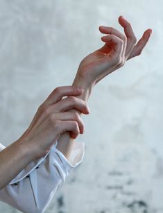 two hands reaching out towards each other with their fingers extended in the air, against a white background