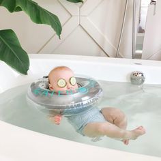 a baby in a bathtub with cucumbers on its face and eyes floating in the water