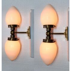 two wall lights with white glass balls on the back of each light, one is turned off