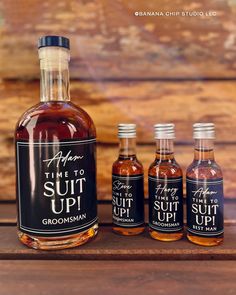 three bottles of syrup sitting on top of a wooden table