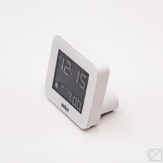 an alarm clock on a white surface