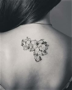 a black and white photo of a woman's back shoulder with flowers on it