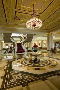 an elegant lobby with chandelier and marble floors