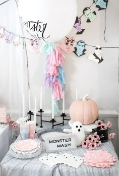 a table topped with lots of decorations next to a white balloon and some paper garlands