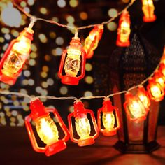 lanterns are hanging on a string with lights in the background