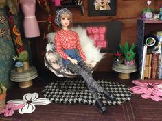 a doll is sitting on a chair in a room with other dolls and decorations around it