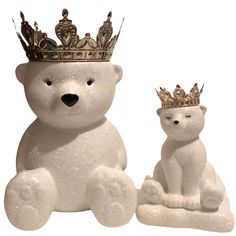 a white polar bear with a gold crown on its head and another one sitting next to it