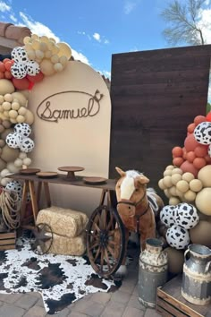 a horse is standing in front of a sign with balloons and other items around it