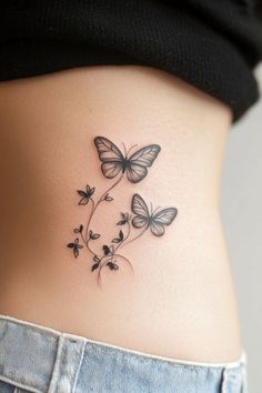 a woman's stomach with two butterflies on it and flowers growing out of the side