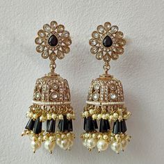 Embrace glamour with our Black Crystal and Pearl Suspended Kundan Jhumka Set - a premium choice in Indian and Pakistani earrings, echoing the splendor of Bollywood. These exquisite jhumka earrings showcase a fusion of black crystals and pearls, enhanced by intricate Kundan detailing. Elevate your style with this statement set, perfectly marrying traditional elegance with a touch of modern allure. Whether for a special occasion or a Bollywood-inspired look, these earrings effortlessly capture the essence of sophistication and cultural richness. Materials: Metal Alloy, Crystal, Pearl, Kundan ❋❋ Shipping Methods ❋❋ Standard Delivery - Take up to 8-14 business days (Worldwide). ❋❋ Please be aware that the colors, shades, and texture shown may exhibit minor variations compared to the actual pro Jhumka Set, Kundan Jhumka, Pakistani Earrings, Bollywood Outfits, Indian Earrings, Jhumka Earrings, Black Jewelry, Black Crystals, Black Beads