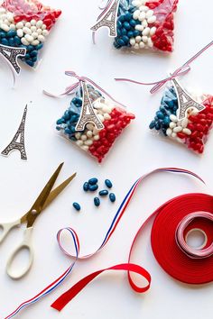 some red, white and blue decorations are on a table with scissors next to them