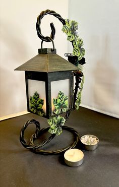 a lit up lantern sitting on top of a table next to a bowl and candle