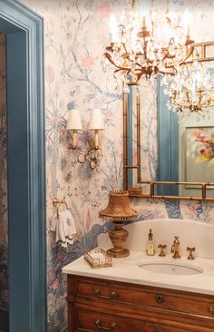 a bathroom with a sink, mirror and chandelier